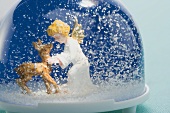 Snow globe containing deer and Christmas angel
