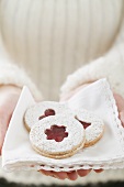 Woman holding jam biscuits on napkin