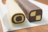 Two rolls of chocolate and plain dough on baking parchment