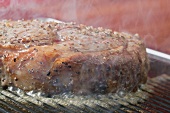 Grilling peppered steak (close-up)