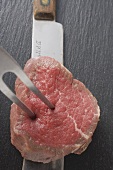 Pricking beef fillet with carving fork