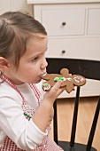 Small girl eating gingerbread man
