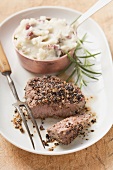 Peppered steak, a piece cut off, with mashed potato