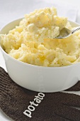 Mashed potato with butter in bowl and on spoon