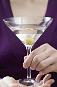 Woman holding Martini with olive