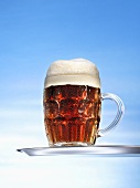 Altbier (top-fermented beer) in glass mug on tray