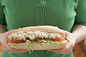 Woman holding chicken salad sandwich