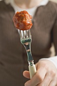 Woman holding meatball on fork