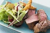 Beef fillet steak with potato wedges and salad