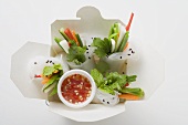 Reispapierröllchen mit Gemüse und Sauce im Take-Out-Behälter