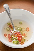Spicy chilli sauce in bowl with spoon