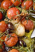 Fried cherry tomatoes with garlic and olives (close-up)