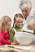 Grandmother & two granddaughters baking Christmas biscuits