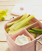 Lunch box containing raw vegetables and dip