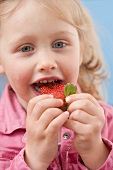 Little girl eating strawberry