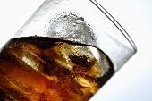 Cola mit Eiswürfeln im Glas (Schräglage)