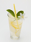 A glass of lemonade with lemon blossom and straw