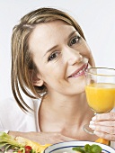 Woman holding a glass of orange juice