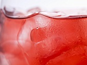 Glass of rosé wine with ice cubes (detail)