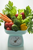 Fresh vegetables and parsley on kitchen scales