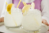 Woman holding a tray of glasses filled with lemonade