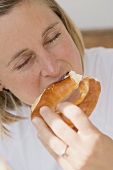 Woman biting into a pretzel