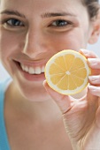 Young woman holding lemon