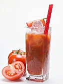 Tomato drink with ice cubes, fresh tomatoes