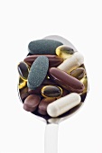 Assorted tablets and capsules on spoon