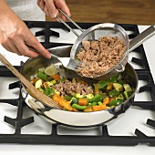 Sweating vegetables and tuna in a frying pan