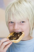 Junge isst Toast mit Vegemite (würziger Brotaufstrich, Australien)