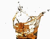 Apple juice splashing out of a glass