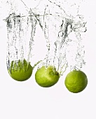 Three limes falling into water