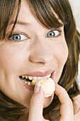 Young woman biting into a chocolate