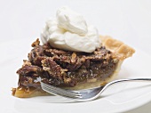 Piece of pecan pie with cream