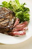 Partially Sliced Steak; Rare; Side Salad