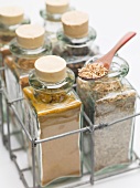 Various spices in small glass bottles and on spoon