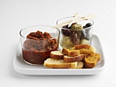 Pepper and tomato tapenade, olives and slices of bread