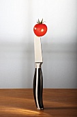 Cherry tomato speared on a vegetable knife