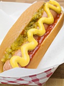 Ein Hot dog mit Senf, Zwiebelrelish und Ketchup