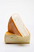 Two pieces of washed-rind cheese