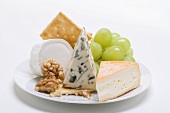 Cheese plate with crackers, nuts and grapes
