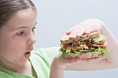 Girl looking at a large sandwich