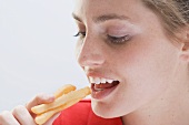 Woman about to put three chips in her mouth