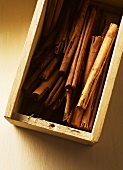 Cinnamon sticks in wooden box (overhead view)