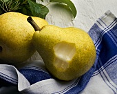 Two Pears on Dish Towel, One with Bite Taken Out
