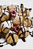 Profiteroles with Chocolate Syrup, Powdered Sugar and Raspberries
