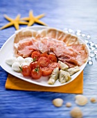 Antipasti of ham, mozzarella, tomatoes and artichoke
