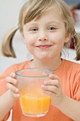 Little girl drinking orange juice