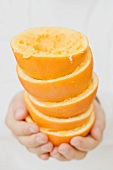 Hände halten ausgepresste Orangen